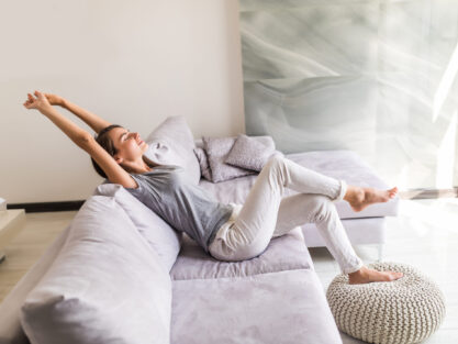 Closeup of a smiling young woman lying on couch