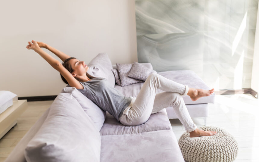 Closeup of a smiling young woman lying on couch