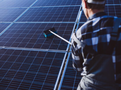 Man worker in the firld by the solar panels