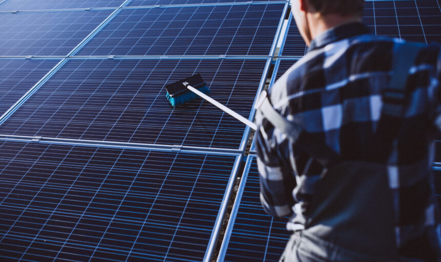 Man worker in the firld by the solar panels